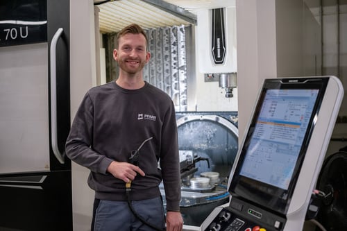 Freundlicher dualer Student (m/w/d) im Bereich BISS-Maschinenbau an einer Maschine.